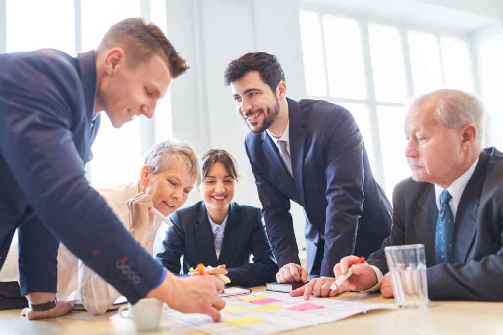A team of colleagues discusses a concept together around a table.