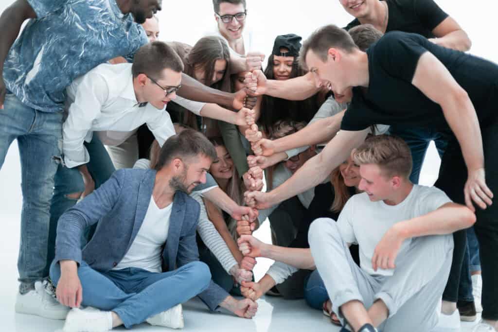 12 gut gelaunte Menschen haben aus ihren Fäusten einen Turm gebaut, der für Zusammenhalt steht.